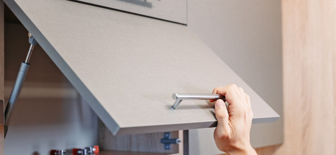 man hand open kitchen cupboard with handle